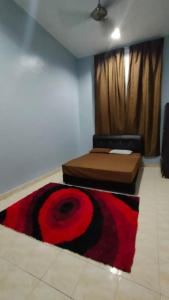 a room with a bed and a rug on the floor at Rosspine Homestay in Jitra
