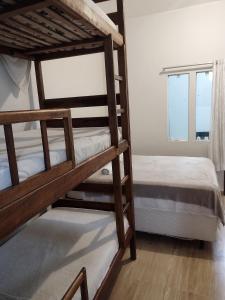 a bedroom with two bunk beds and a window at Hospedaje MorroSP in Morro de São Paulo