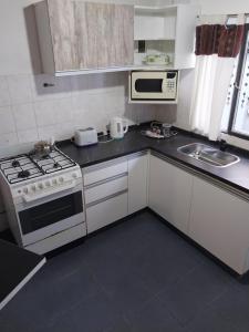 a small kitchen with a stove and a microwave at Espacio km3 in Comodoro Rivadavia