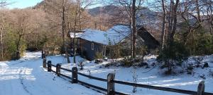 a house in the snow with a fence at Cabaña Fio-Fio Conguillio National Park in Conguillío