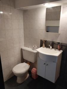 a bathroom with a toilet and a sink at Espacio km3 in Comodoro Rivadavia