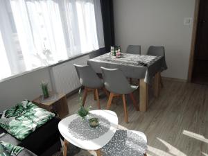 uma sala de estar com mesa e cadeiras em Holiday apartment near the beach in Dziwnów em Dziwnów