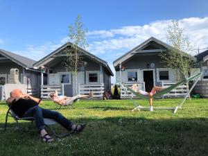 a man sitting in lawn chairs in a yard at New holiday homes for 2 people in Dziwn wek in Dziwnówek