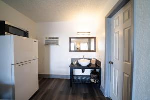 a small kitchen with a sink and a refrigerator at OYO Hotel Ocala, FL I-75 in Ocala