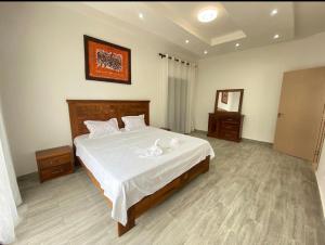 1 dormitorio con 1 cama grande con sábanas blancas en pieds dans l'eau nianing, en Nianing