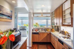 a kitchen with wooden cabinets and a large window at Lillikoi in Honolulu