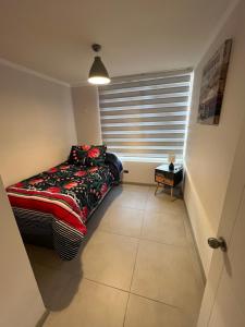 Zimmer mit einem Bett und einem Fenster mit einem Kissen in der Unterkunft Departamento Coquimbo - La Serena in Coquimbo