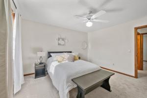ein weißes Schlafzimmer mit einem Bett und einem Deckenventilator in der Unterkunft Spacious Townhouse Finished Basement in Toledo