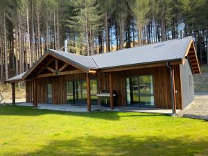 a cabin with a metal roof on a grass field at Blue Mountain Lake Lodge in Fairlie