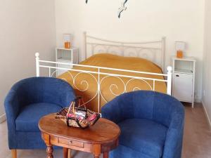 ein Schlafzimmer mit zwei blauen Stühlen und einem Bett in der Unterkunft Studio charmant proche centre, terrasse privée, parking, 2km plage - Saint-Jean-de-Monts - FR-1-426-532 in Saint-Jean-de-Monts