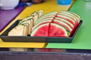 einen Teller mit Wassermelonenschnitten auf einem Tablett auf einem Tisch in der Unterkunft The Funky Monkey Hostel in Haad Rin
