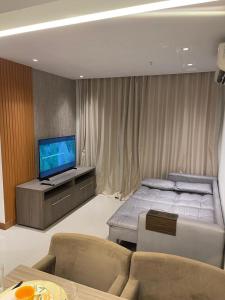 a bedroom with a bed and a flat screen tv at Flat Hotel Samba Barra Jeunesse Arena Projac Rio Centro in Rio de Janeiro