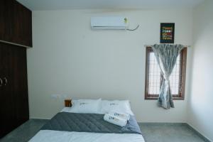 1 dormitorio con cama y ventana en Live Inn JP Nagar, en Tiruchchirāppalli