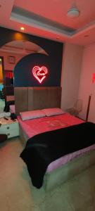 a bedroom with a bed with a heart sign on the wall at Vinanda Home Stay in New Delhi