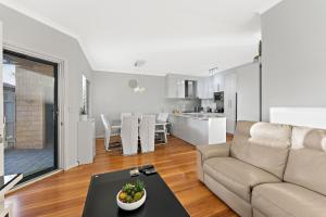 una sala de estar con un sofá y una mesa en Modern Scarborough Townhouse, en Perth