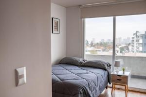 a bedroom with a bed and a large window at Estancia Perfecta, Te esperamos! in Santiago