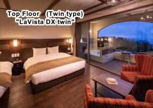 a hotel room with a bed and a balcony at La Vista Kirishima Hills in Kirishima