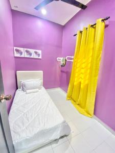 a purple and yellow room with a bed and a shower at AISY HOMESTAY - Rumah 2,3 in Kampong Tanjong Karang