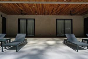 Habitación con 3 sillas y techo de madera. en Villa Estrella Pavones en Pavones