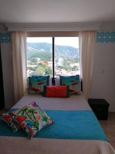 a bedroom with a bed with a large window at Apartamento con piscina cerca al mar Amoblado Rodadero Sur in Gaira