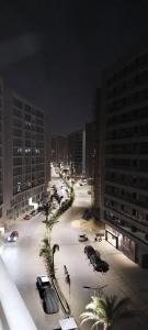 a city street at night with cars parked in a parking lot at The Panoramic View - Luxury Apartments in Cairo in Cairo