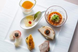 a white plate topped with food and a bowl of soup at Sendai Kokusai Hotel in Sendai