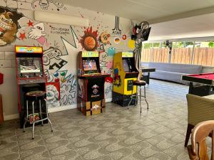 une salle avec des jeux d'arcade et un mur orné de graffitis dans l'établissement Main House 3 Bed 2 Bath & Guest House 1 Bed 1 Bath, à Miami