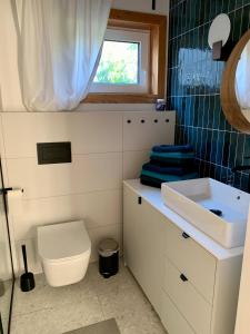 a bathroom with a toilet and a sink and a window at Baltic Homes Lubiatowo in Lubiatowo