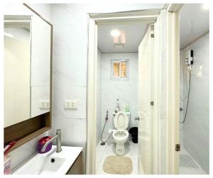 bagno con servizi igienici, lavandino e specchio di Velasquez Farmhouse/Affordable Holiday Rental Near Hundred Islands 