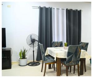 una sala da pranzo con tavolo, sedie e ventilatore di Velasquez Farmhouse/Affordable Holiday Rental Near Hundred Islands 
