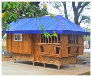 una grande casa in legno con tetto blu di Velasquez Farmhouse/Affordable Holiday Rental Near Hundred Islands 