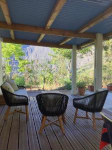 eine Veranda mit Stühlen und einem Tisch auf einer Terrasse in der Unterkunft L’îlet Songes in Cilaos