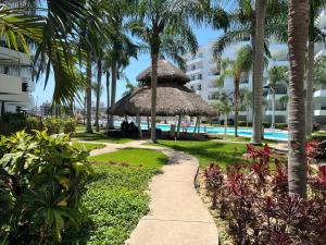 a pathway leading to a resort with palm trees at Departamento en Marina in Mazatlán