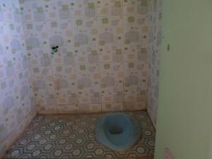a bathroom with a blue toilet in the corner at SPOT ON 92666 Rumah Kos Arafah Syariah in Probolinggo
