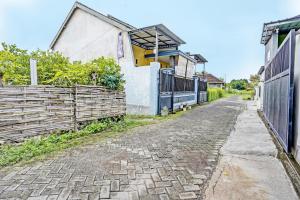 une rue vide avec une clôture et une maison dans l'établissement SPOT ON 92673 Gang Songo Syariah Homestay, à Banyuwangi