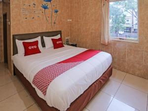 ein Schlafzimmer mit einem großen Bett mit roten Kissen in der Unterkunft SUPER OYO 92672 Hotel Bsd in South Tangerang