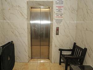 a elevator door in a building with a chair at SUPER OYO 92672 Hotel Bsd in South Tangerang