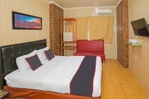 a bedroom with a bed and a red chair at Super OYO Capital O 92676 Hotel Sion Holiday in South Tangerang