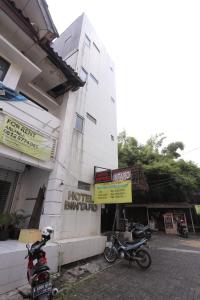 due moto parcheggiate di fronte a un edificio di Super OYO 92677 Hotel Bintaro a South Tangerang