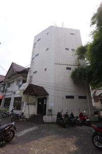 um edifício branco com motos estacionadas em frente em OYO 92677 Hotel Bintaro em South Tangerang