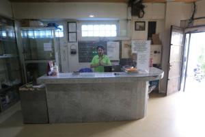 a woman standing behind a counter in a kitchen at OYO 92677 Hotel Bintaro in South Tangerang