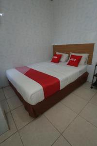 a bed with red pillows in a room at OYO 92677 Hotel Bintaro in South Tangerang