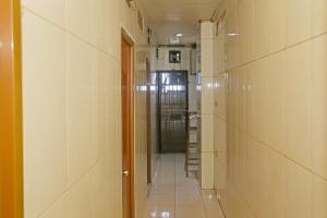 um corredor com paredes de azulejos brancos e um longo corredor em OYO 92678 Hotel Melati em South Tangerang