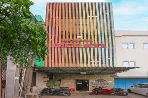 um hotel ao lado de um edifício alto com motos estacionadas fora em OYO 92678 Hotel Melati em South Tangerang
