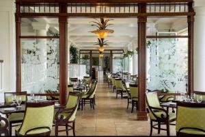 a dining room with tables and chairs in a restaurant at Luxury Gem at Kauai Beach Resort & Spa in Lihue