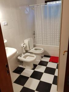 a bathroom with a toilet and a checkered floor at Residencial Las Lechuzas in Villa Anizacate