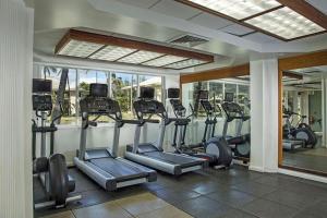 a gym with treadmills and ellipticals in a room at Luxury Gem at Kauai Beach Resort & Spa in Lihue