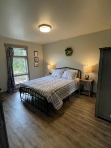 Un dormitorio con una cama grande y una ventana en The Inn at Liberty Farms en Sunshine
