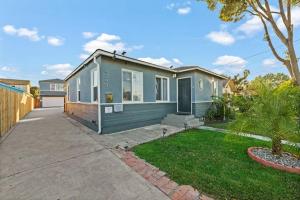 a small blue house with a driveway at Spacious Centrally Located NEW 2 Bedroom Property! in Inglewood