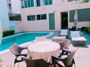 a table and chairs next to a swimming pool at Tiki’s Penth in Acapulco